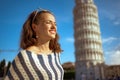 Relaxed trendy woman standing near leaning tower in Pisa, Italy